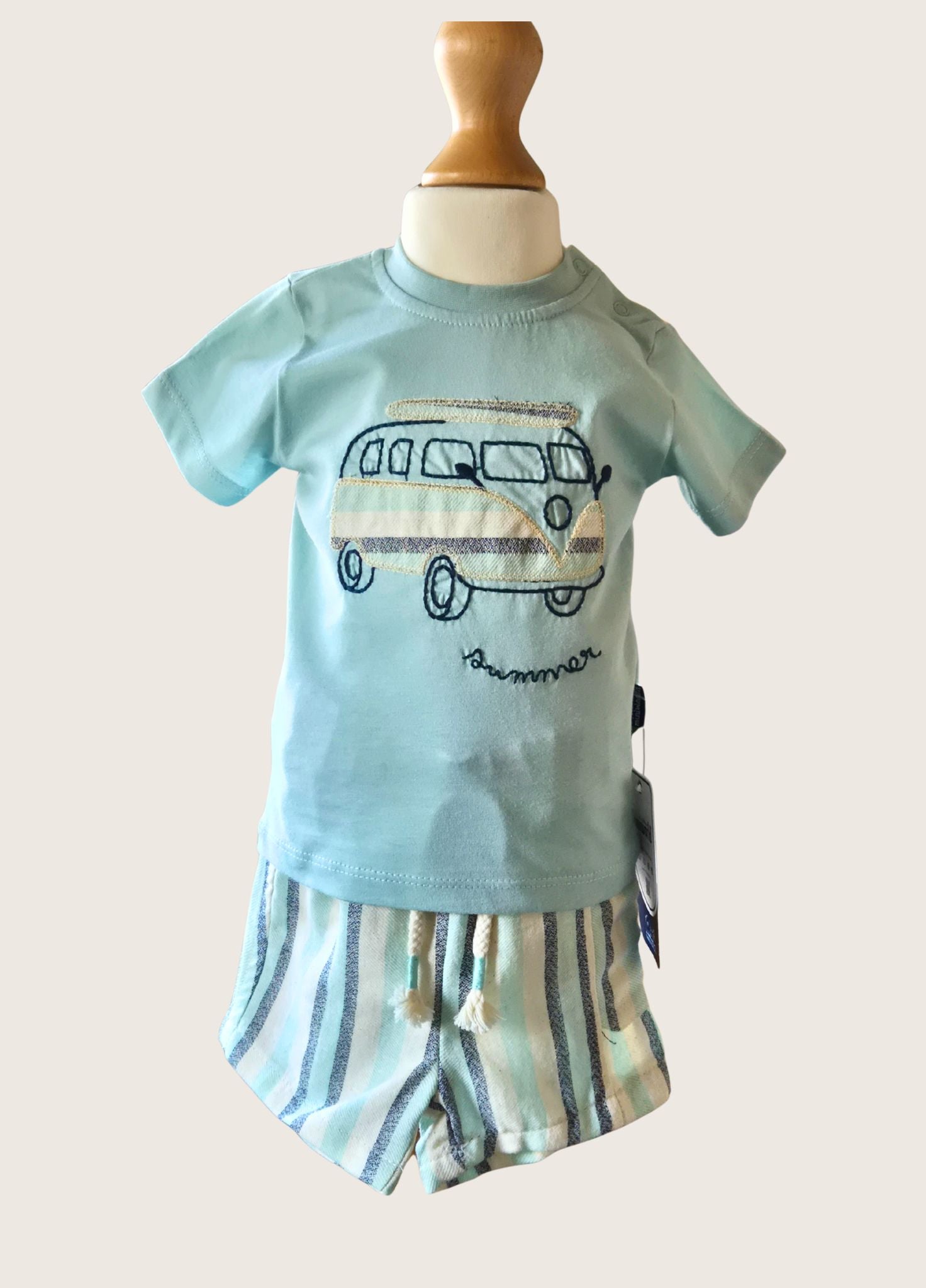 Children's outfit with a light blue shirt and striped shorts on a mannequin against a white background.