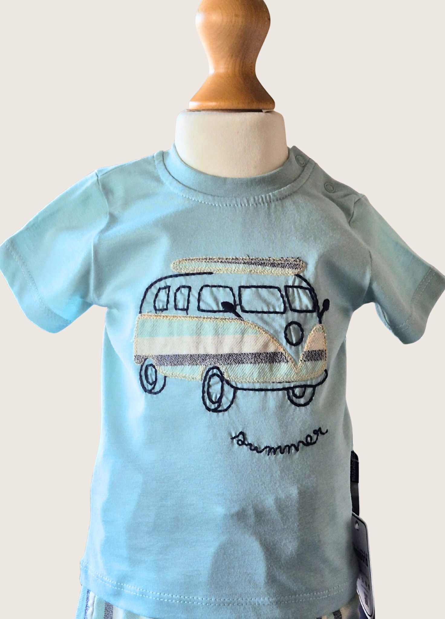Light blue t-shirt with a vintage van graphic on a mannequin against a plain background