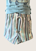 Children's outfit with a light blue top and striped shorts on a beige background