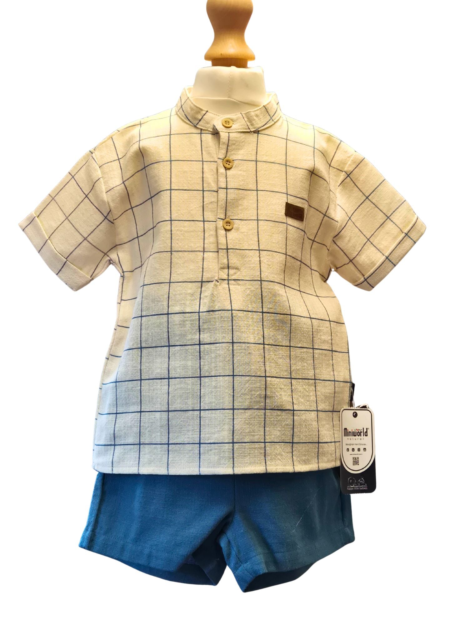 Children's outfit with checkered shirt and blue shorts on a mannequin against a white background.