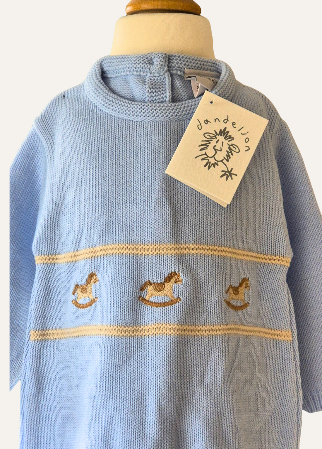Baby blue knitted romper from Dandelion with rocking horse motif