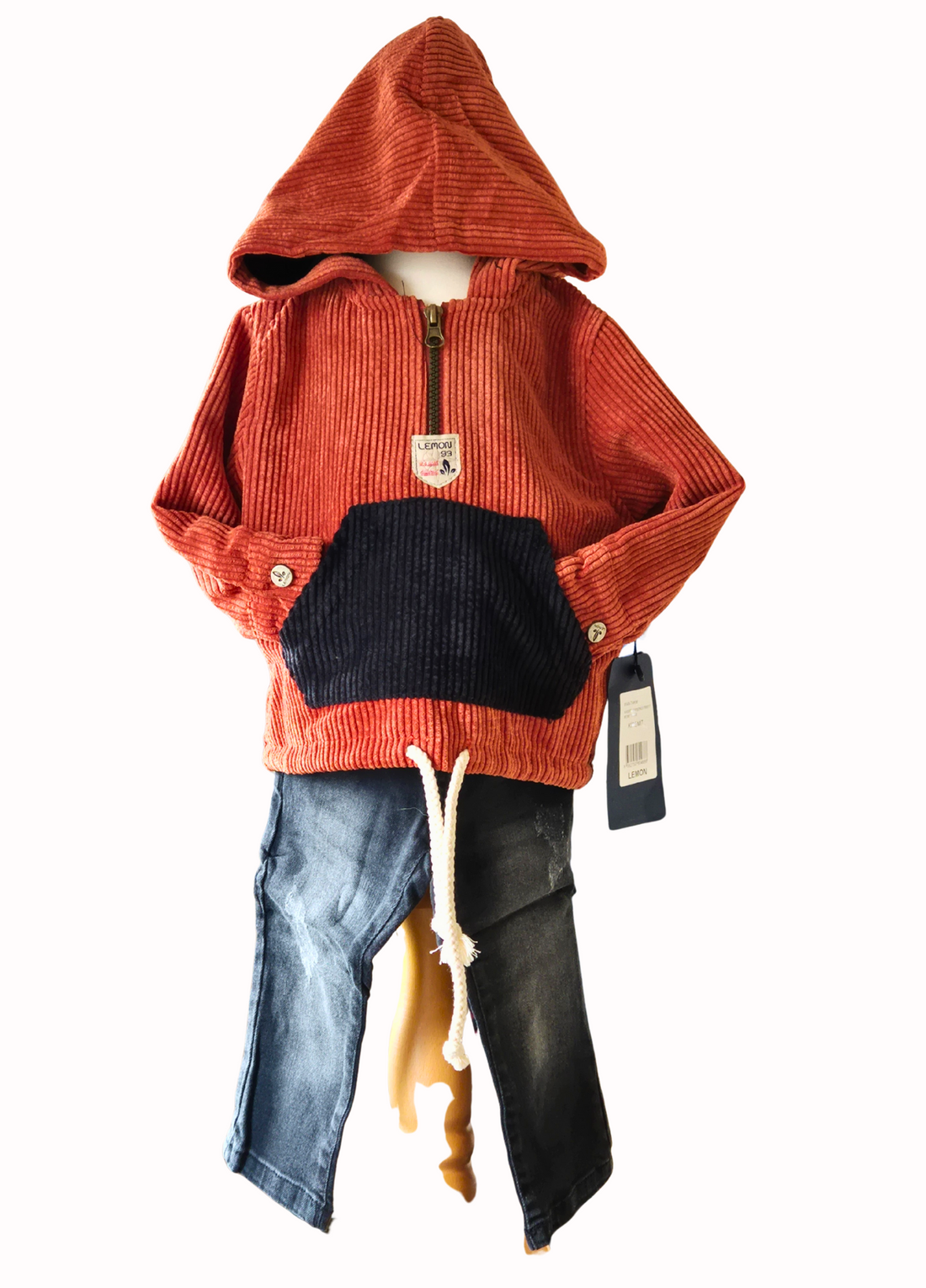 Children's outfit with orange corduroy hoodie, black jeans, on a mannequin against a white background.