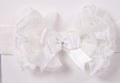 White lace headband with a bow on a light gray background