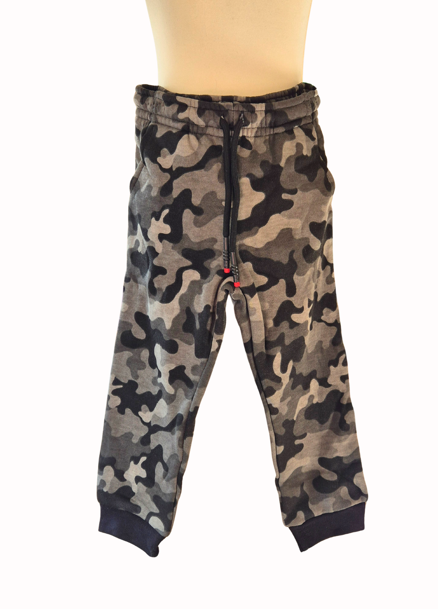Camouflage-patterned pants on a mannequin with a white background