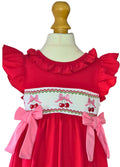 Red dress with ruffled sleeves and pink bows on a mannequin against a white background