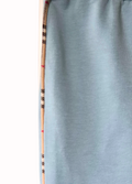 Light blue pants with a patterned strips down the leg held vertically on a white background