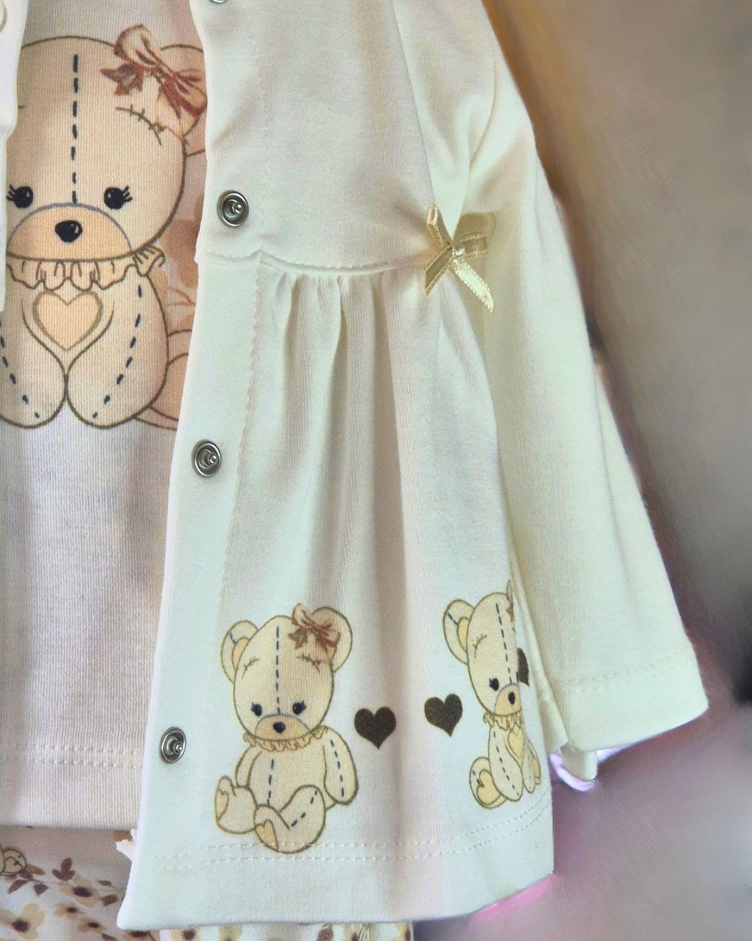 Cream baby jacket with satin bows and teddy bear detail