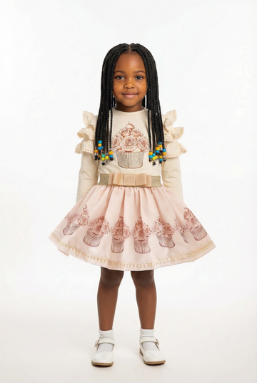 Co ordination cream sparkly cupcake top and skirt set on a young black girl.
