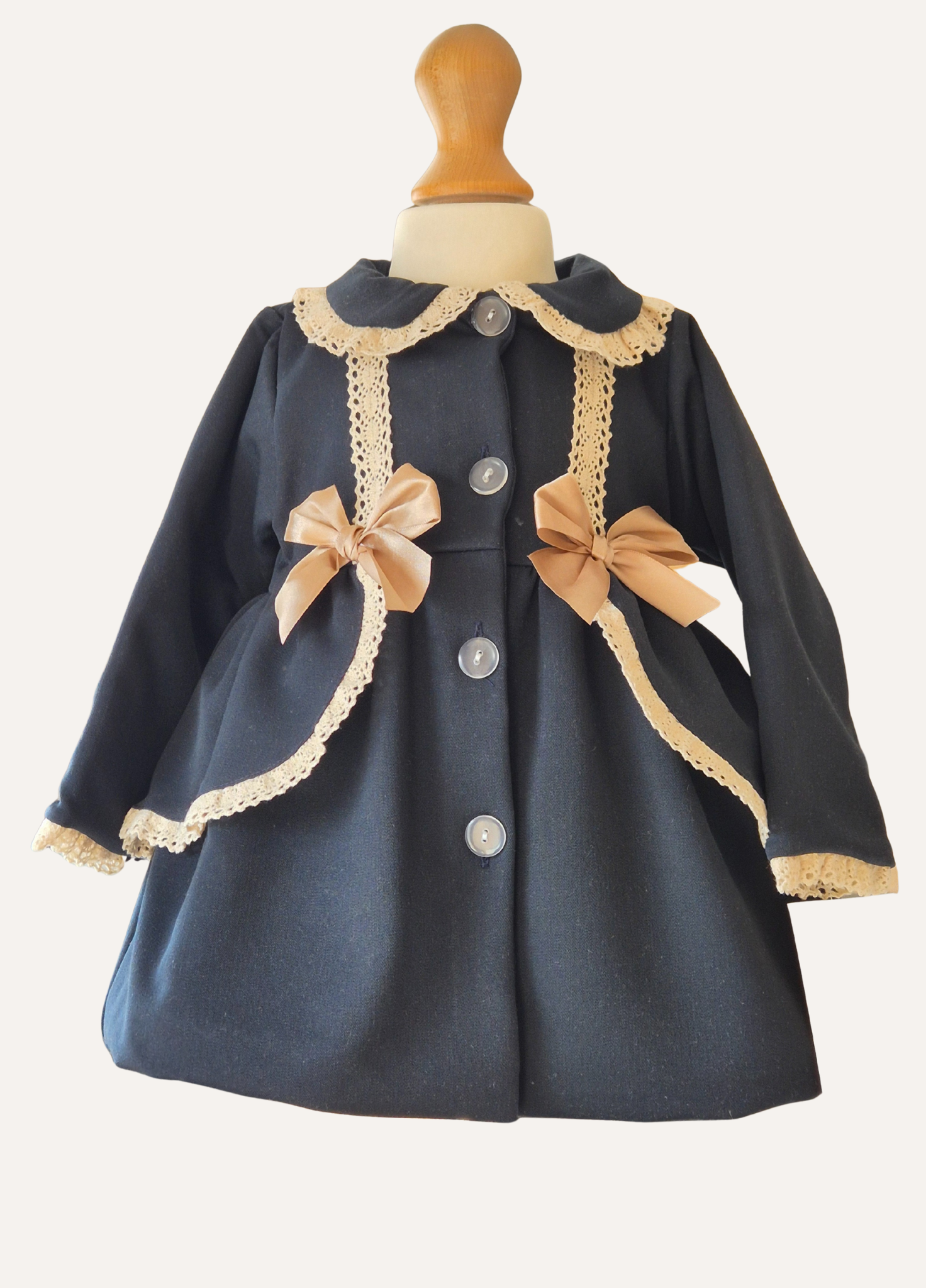 Close up of Girls Navy blue with lace trim and bows spanish coat
