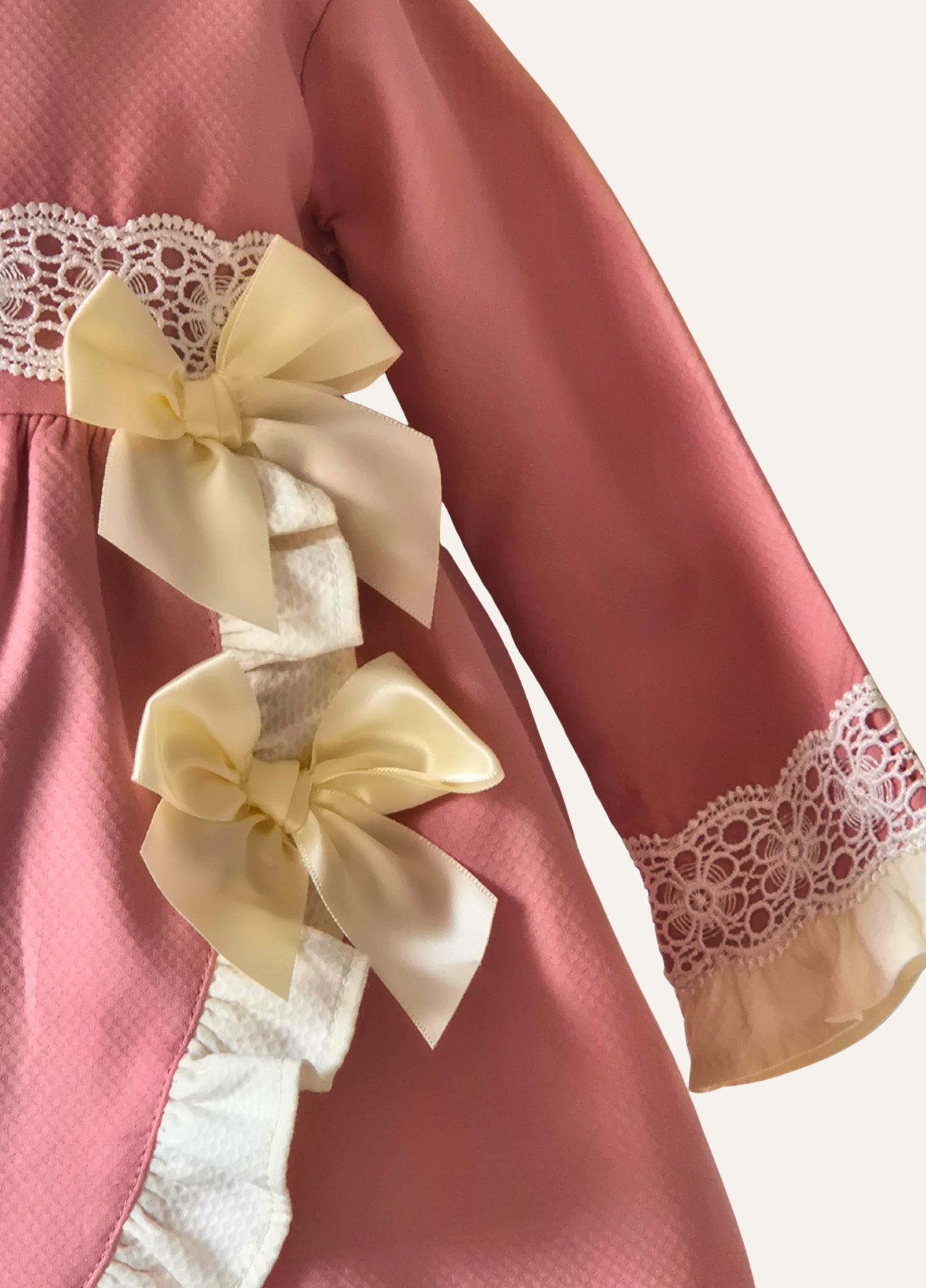 Girls dusky pink spanish dress close up of double bow detail