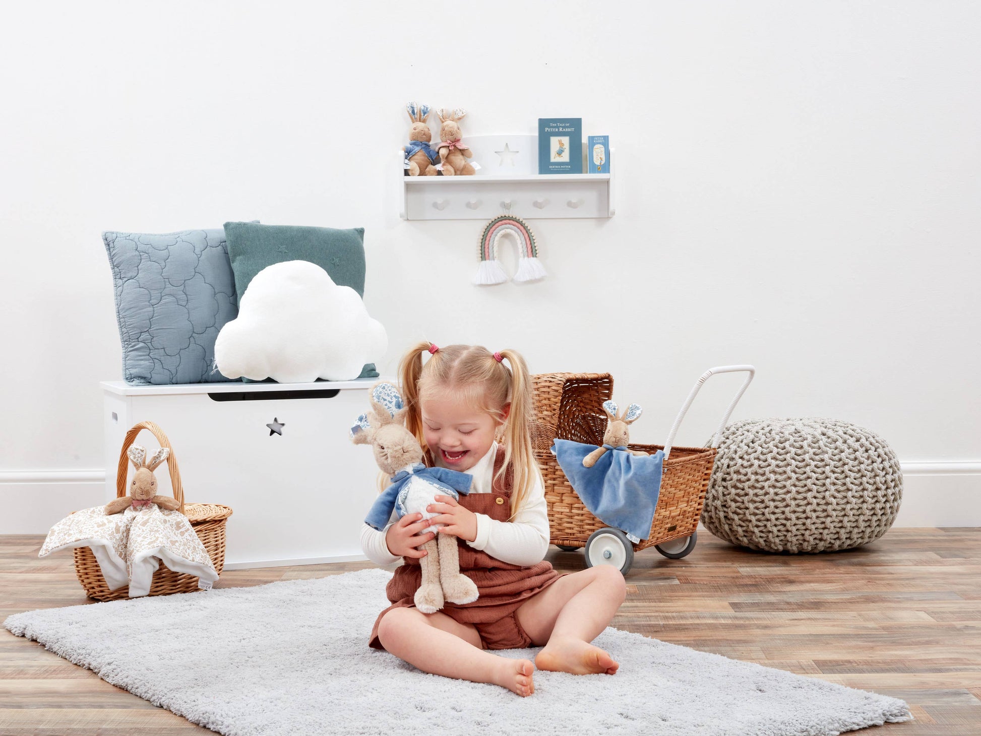 Child playing with toys in a room with a white wall and wooden floor.