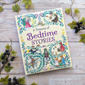 Book titled 'A Treasury of Bedtime Stories' on a wooden surface with decorative elements.