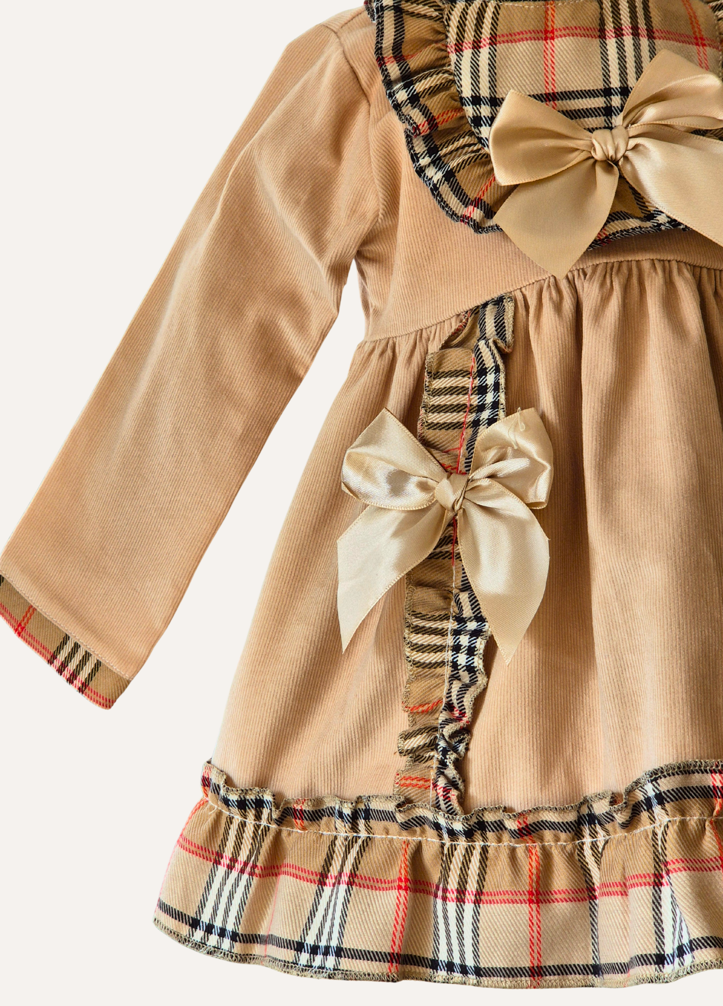 Hemline detail of the Spanish Beige dress with plaid accents and bows