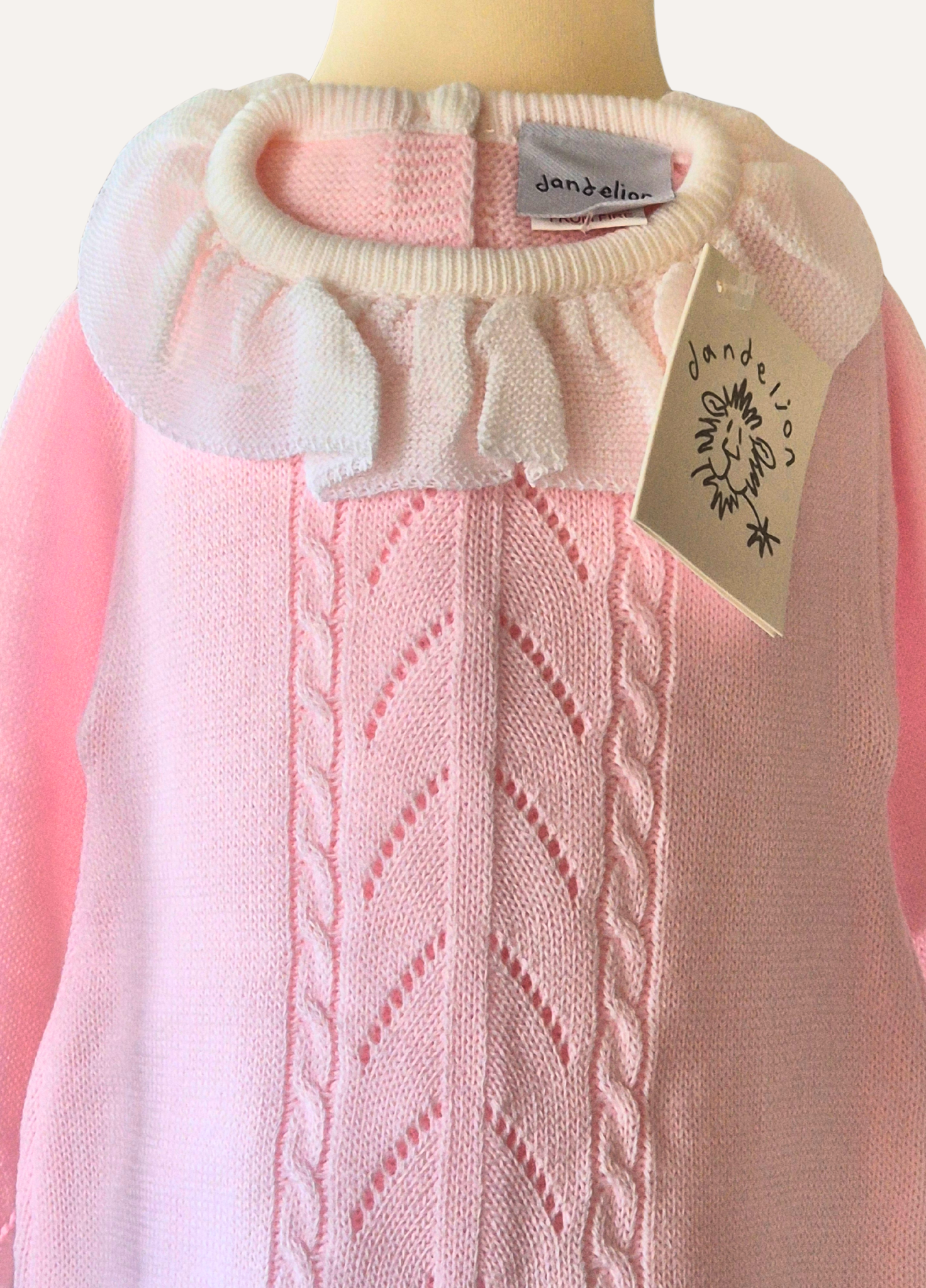 Close up of baby pink knitted romper with white frill collar from Dandelion