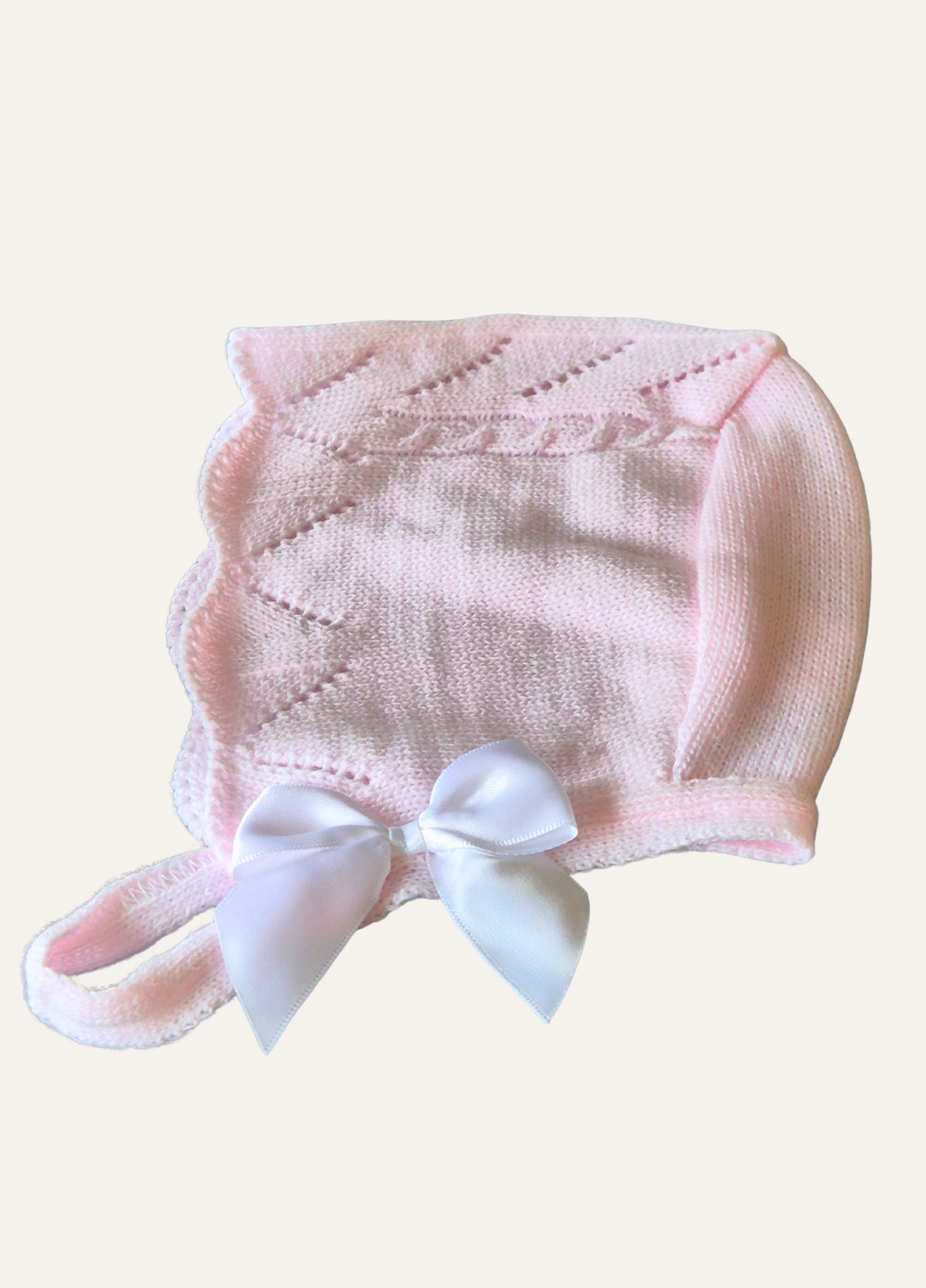 Close up of matching baby pink and white knitted bonnet to match the romper from Dandelion