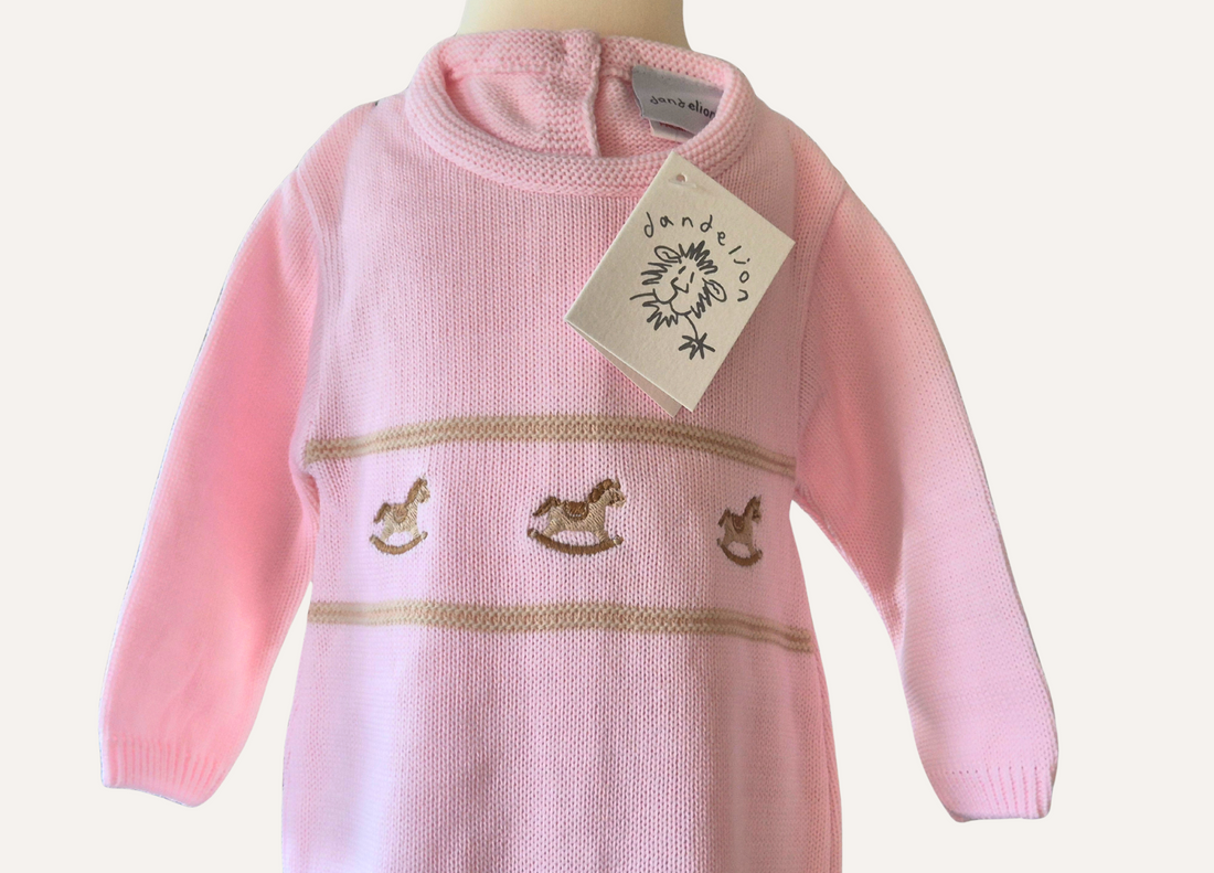 Baby Pink knitted onesie from Dandelion with rocking horse detail