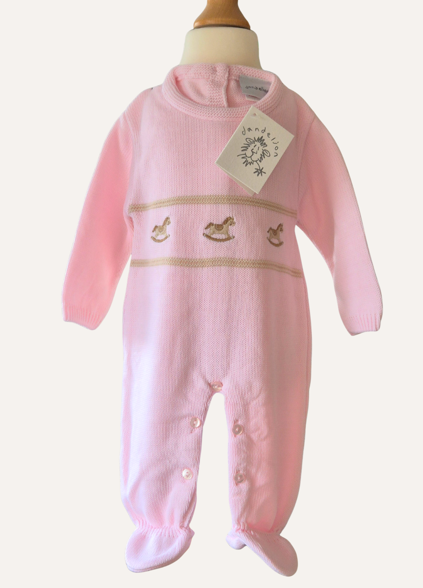 Baby Pink knitted onesie from Dandelion with rocking horse detail