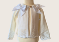Ivory knitted cardigan with double satin bow details on a mannequin against a plain background