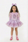 Young girl in a lilac co ordinating skirt and top set featuring a sparkly cupcake design.