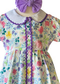 Colorful floral dress with purple accents on a mannequin against a white background