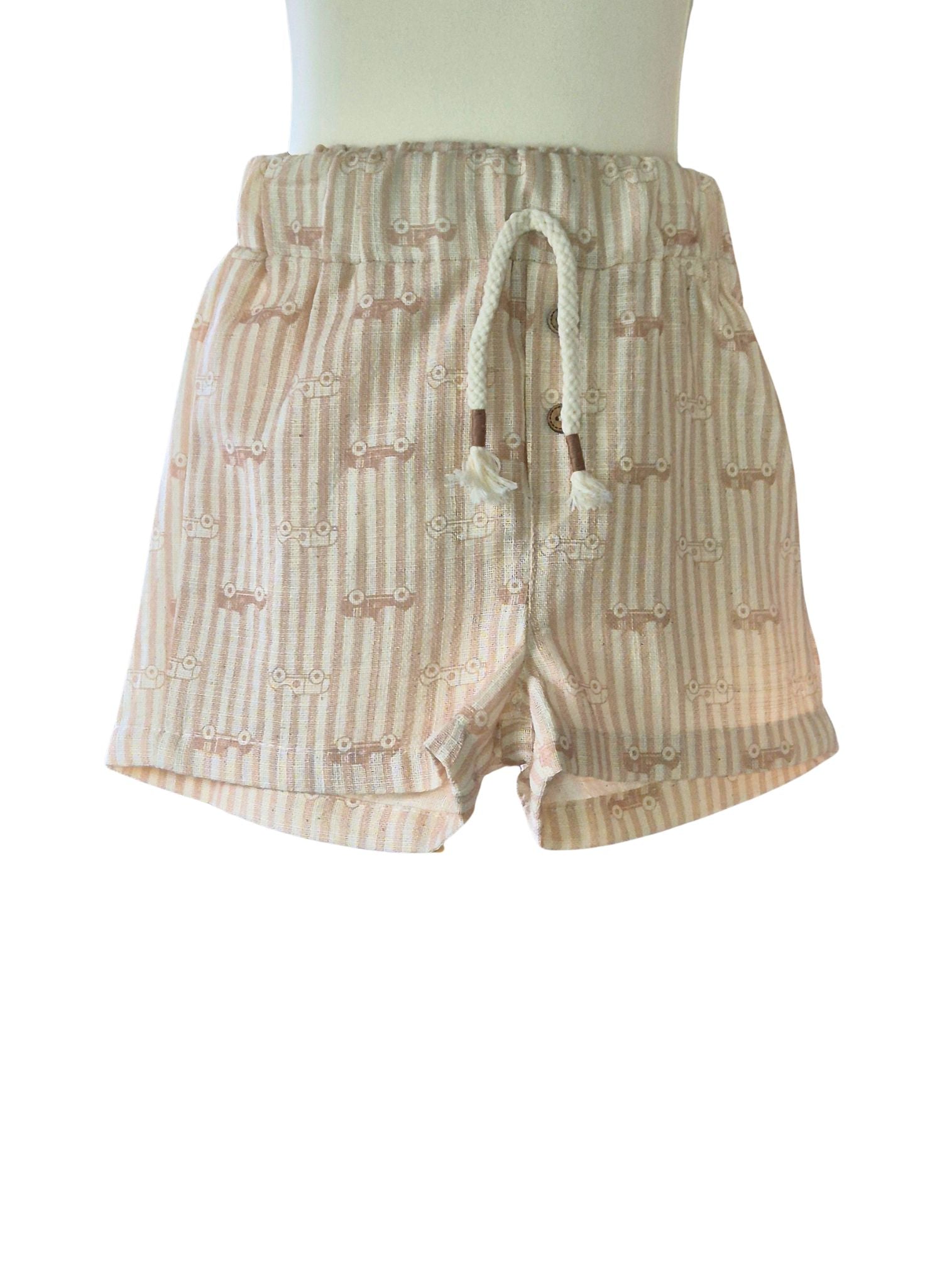 Beige shorts with a subtle stripe and car motif pattern on a white background