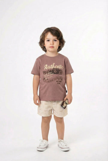 Child wearing a brown t-shirt with text and light-colored shorts on a white background