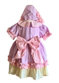 Pastel coloured dress with matching bonnett on a mannequin showing the oversized pink bow on the back of the dress.