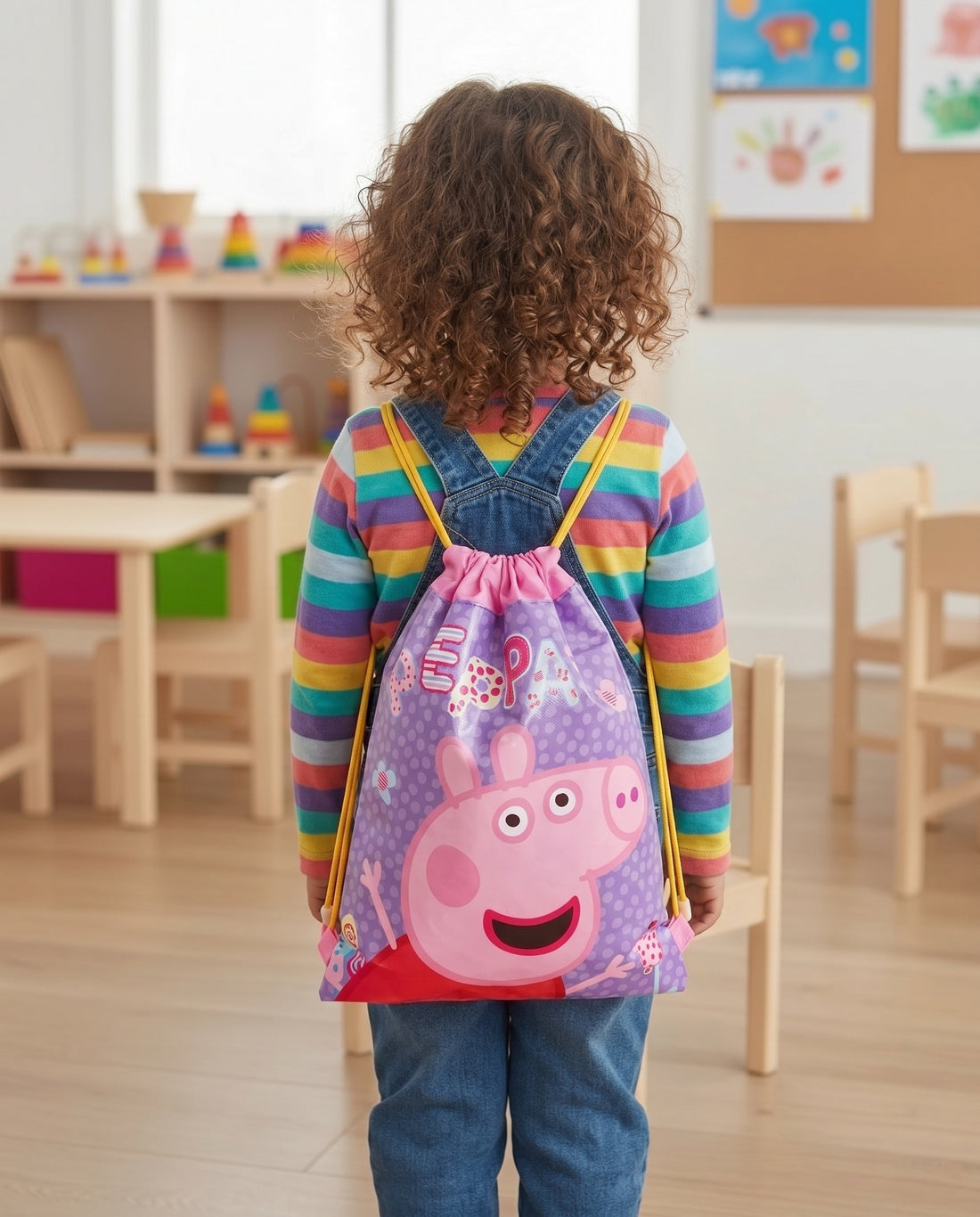 Child carrying Peppa Pig drawstring school bag