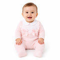 Pink cotton baby sleepsuit with white frilled bib