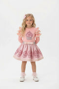 Pretty pink skirt and top featuring a sparkly cupcake design on a young blonde girl.
