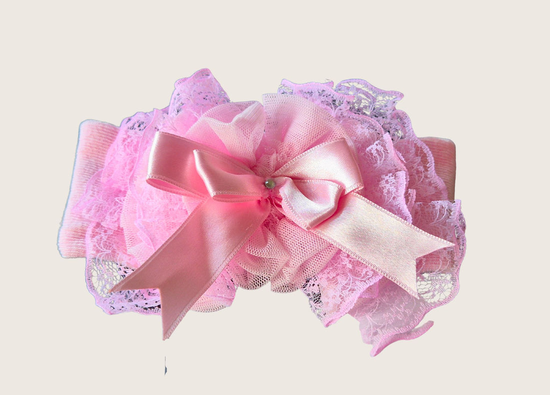 Pink Soft headband withPink bow with ruffles on a white background