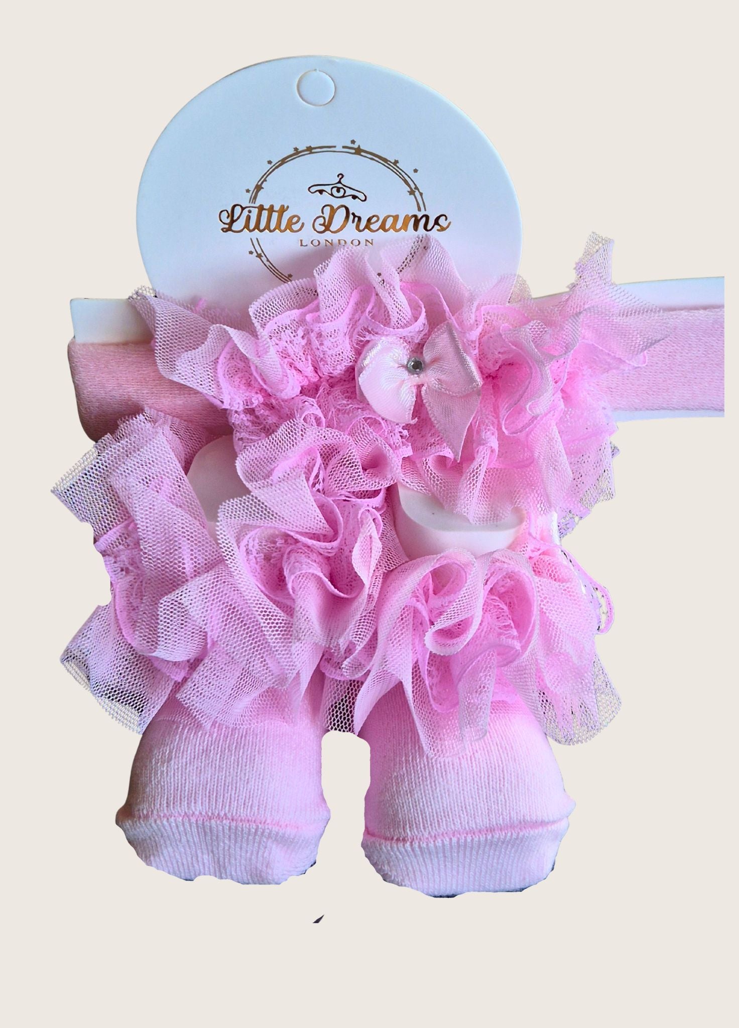 Pink ruffled socks and matching headband on a 'Little Dreams London' branded card