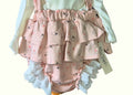 Pink ruffled baby bloomers with heart pattern on a white background