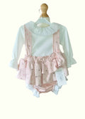Baby outfit with pink ruffled bloomers and white long-sleeve shirt on a mannequin against a white background.