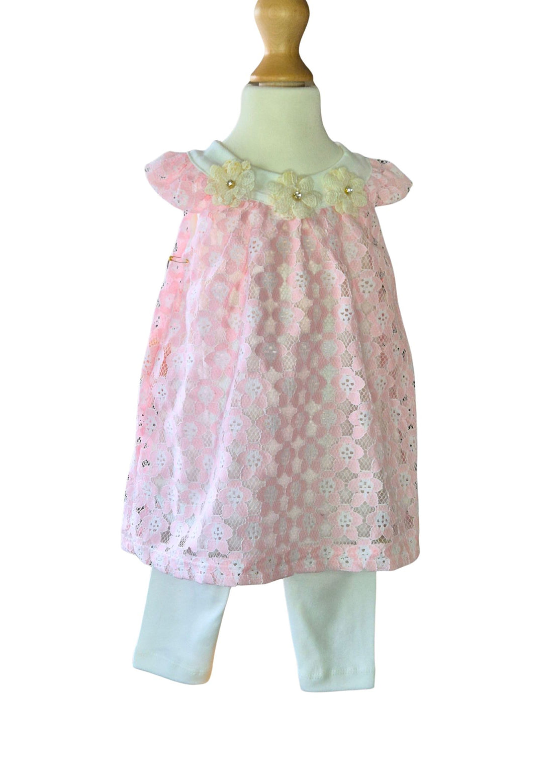 Black toddler girl in a pink lace swing dress with flower detail at the neck and white leggings on a light background.