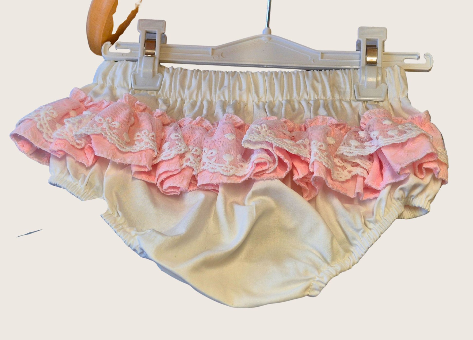 Pair of white knickers with pink and white lace frills to match the dress.