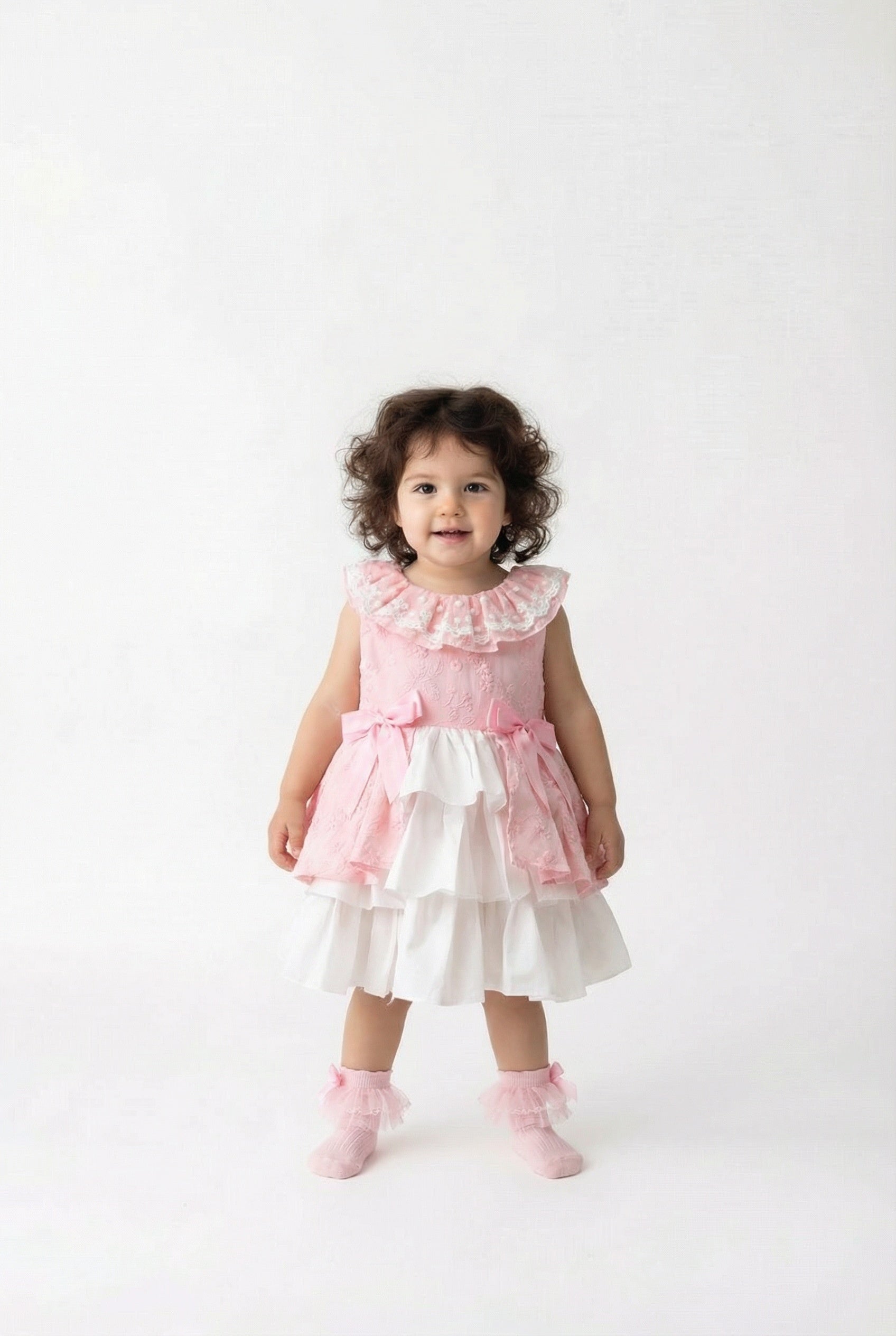 Child wearing a pink and white dress on a white background