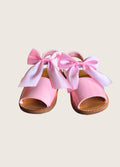 Pink sandals with large bows on a beige background