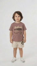 Young boy in a mocha authentic graphic t shirt and co ordinating shorts on a light background.