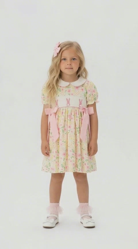 Pastel lemon floral dress with pink rabbit smocking and a white  Peter Pan collar on a blonde young girl.