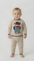 Toddler wear a knitted suit with a cowboy bear on the jumper on a white background