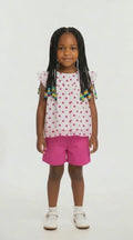 Girls cerise pink knee length shorts and white polka dot floaty top summer outfit
