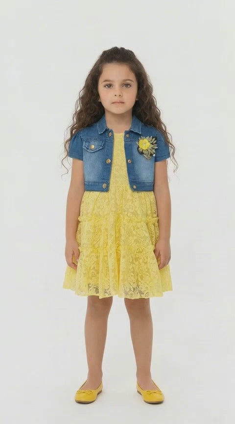 Girl with dark long hair in a lemon lace tiered dress with denim shrug on a light background.