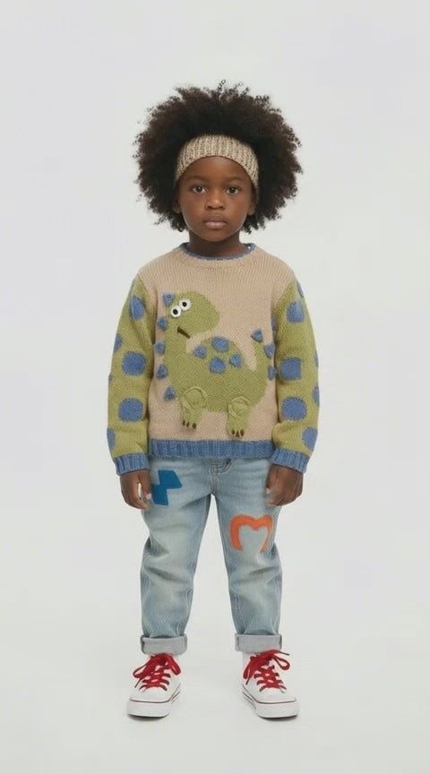 Little black boy with afro hair in a dragon jumper and jeans