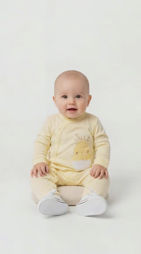 Baby in lemon Just Hatched Sleep Suit with a Chick comine out of a cracked Egg