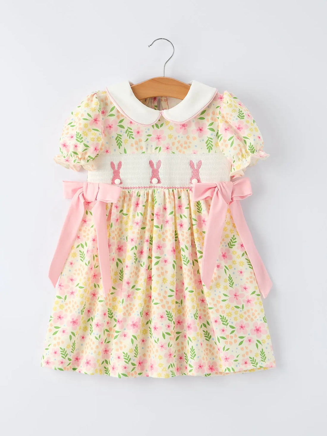 Pastel lemon floral dress with pink rabbit smocking and a white  Peter Pan collar on a blonde young girl.