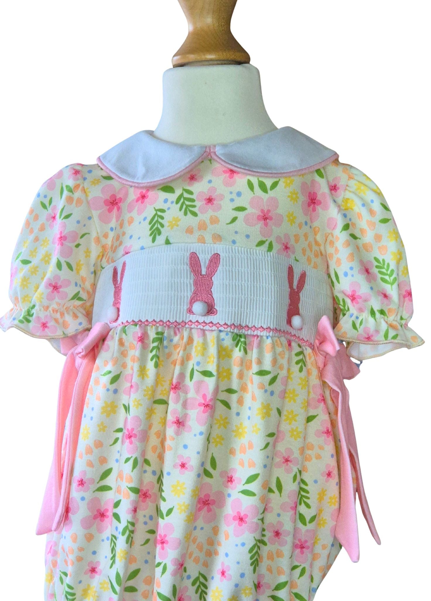 Floral romper with bunny design on a mannequin against a white background