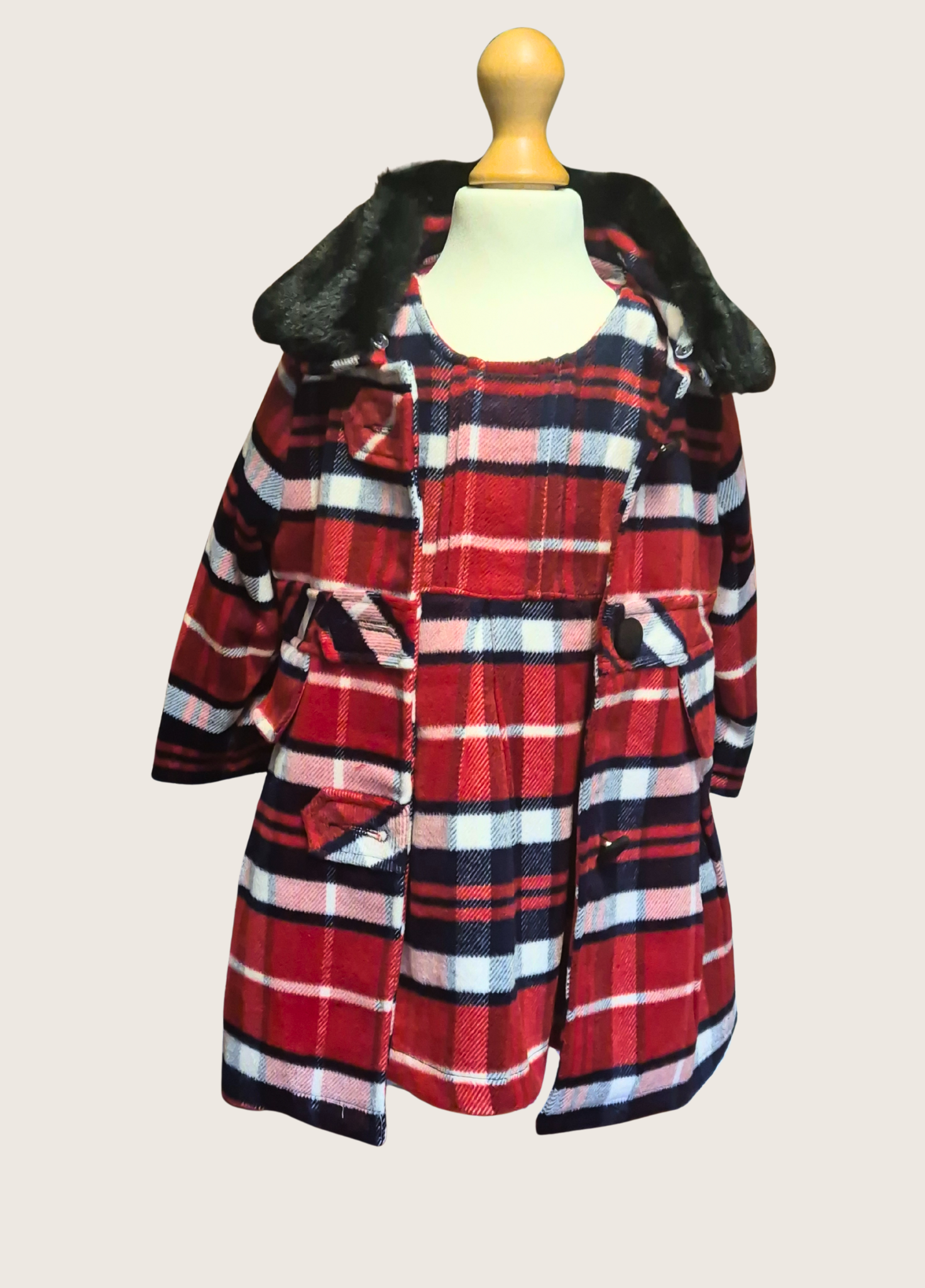 Plaid coat with fur hood on a mannequin against a plain background