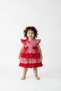 Child wearing a red checkered dress on a white background