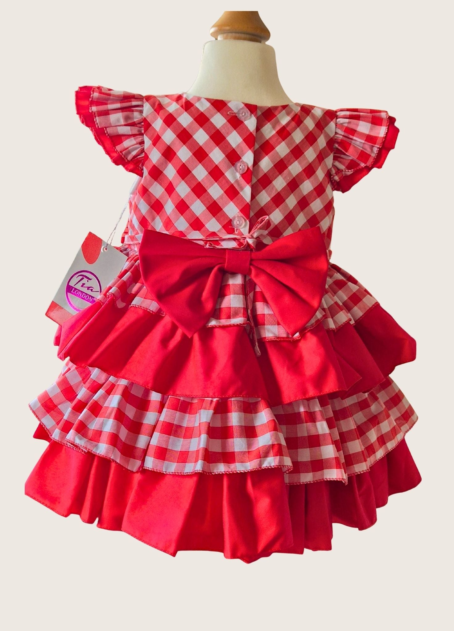 Red and white checkered dress with ruffles on a mannequin against a white background